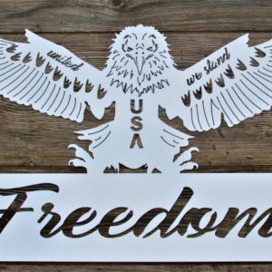 White metal sign with an eagle perched on large letters that spell FREEDOM. On its wings are the words United We Stand with vertical USA letters on the chest.