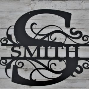 A laser cut monogram sign of the surname Smith centered inside a much larger letter S